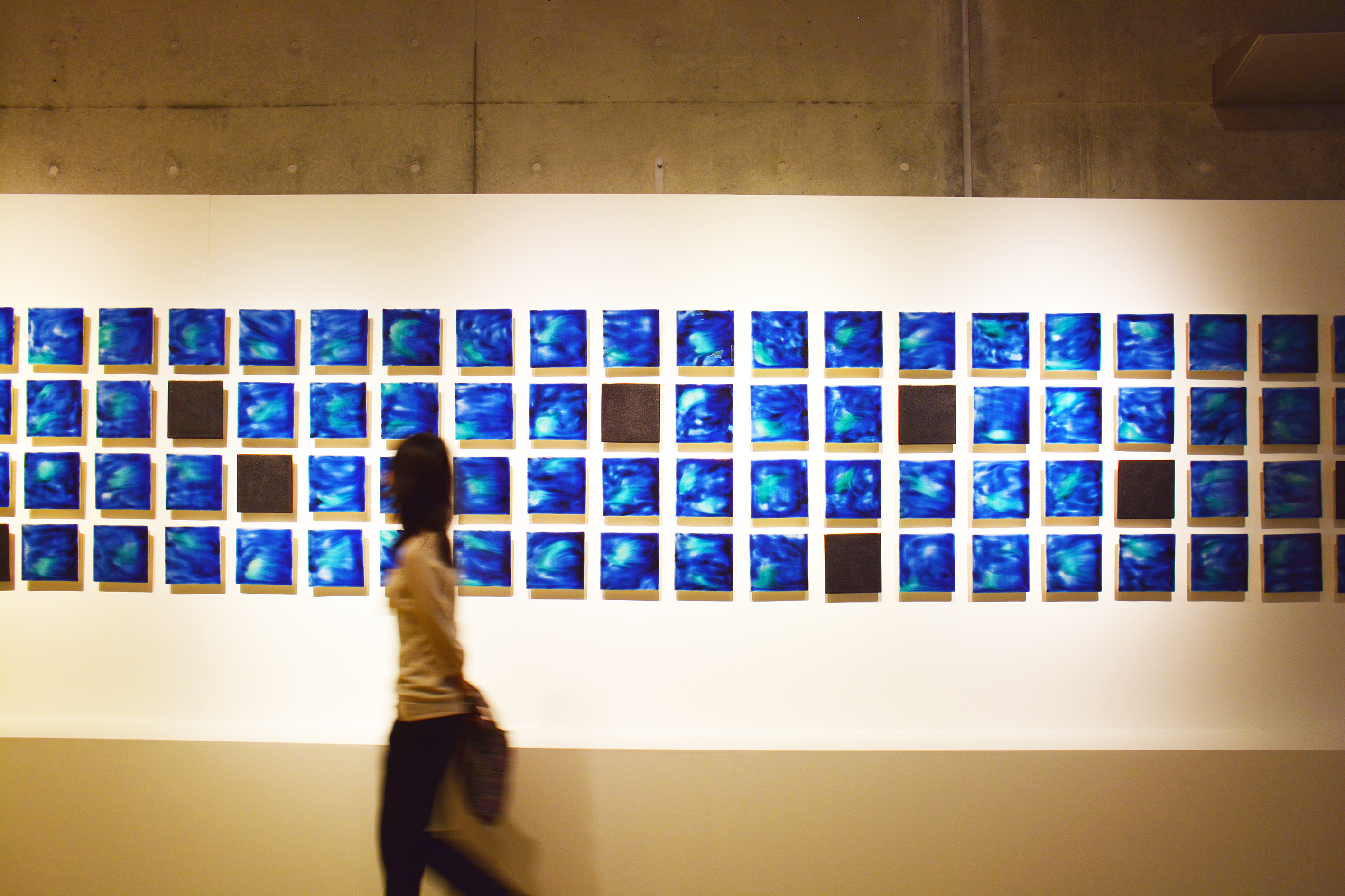 トンネル・ギャラリーに展示されている石垣焼の作品「Ishigaki Blue」を眺める来場者(OIST提供)