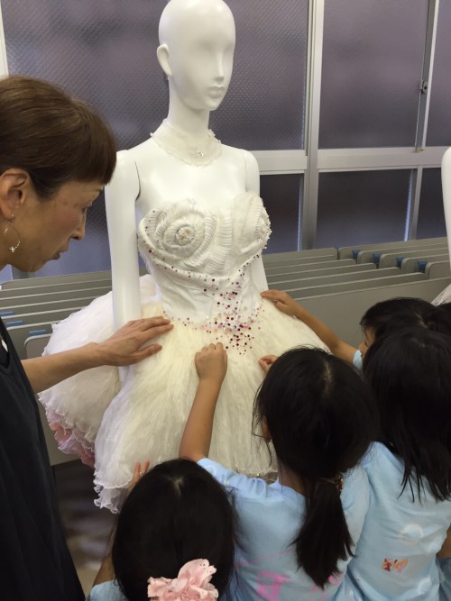 デザインの専門学校でドレスを触る子どもたち