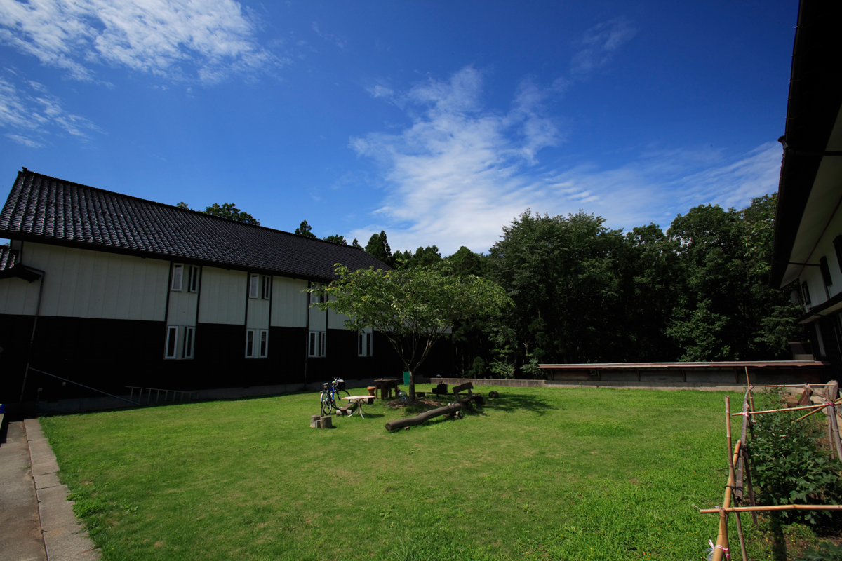 新潟県佐渡市南西部に位置する「鼓童村」は約４万坪の敷地を有し、本部棟、稽古場、住居、工房・スタジオなどの施設がある
