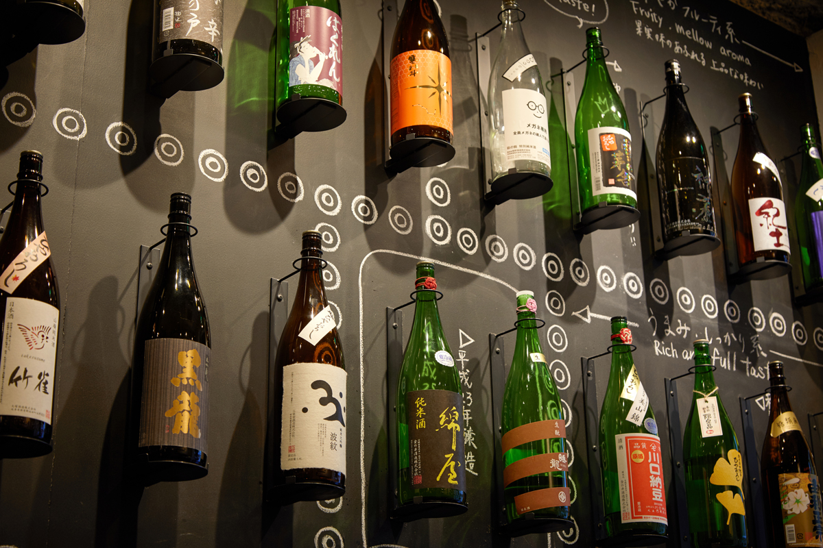 壁面に陳列された一升瓶と、日本酒について丁寧に書かれた説明
