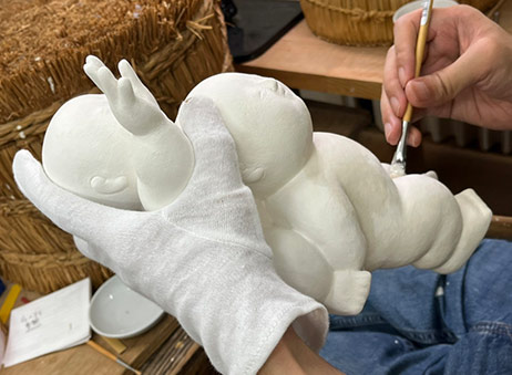 面庄家での人形制作風景。何度も胡粉を塗り重ねる昔ながらの手法で制作される
