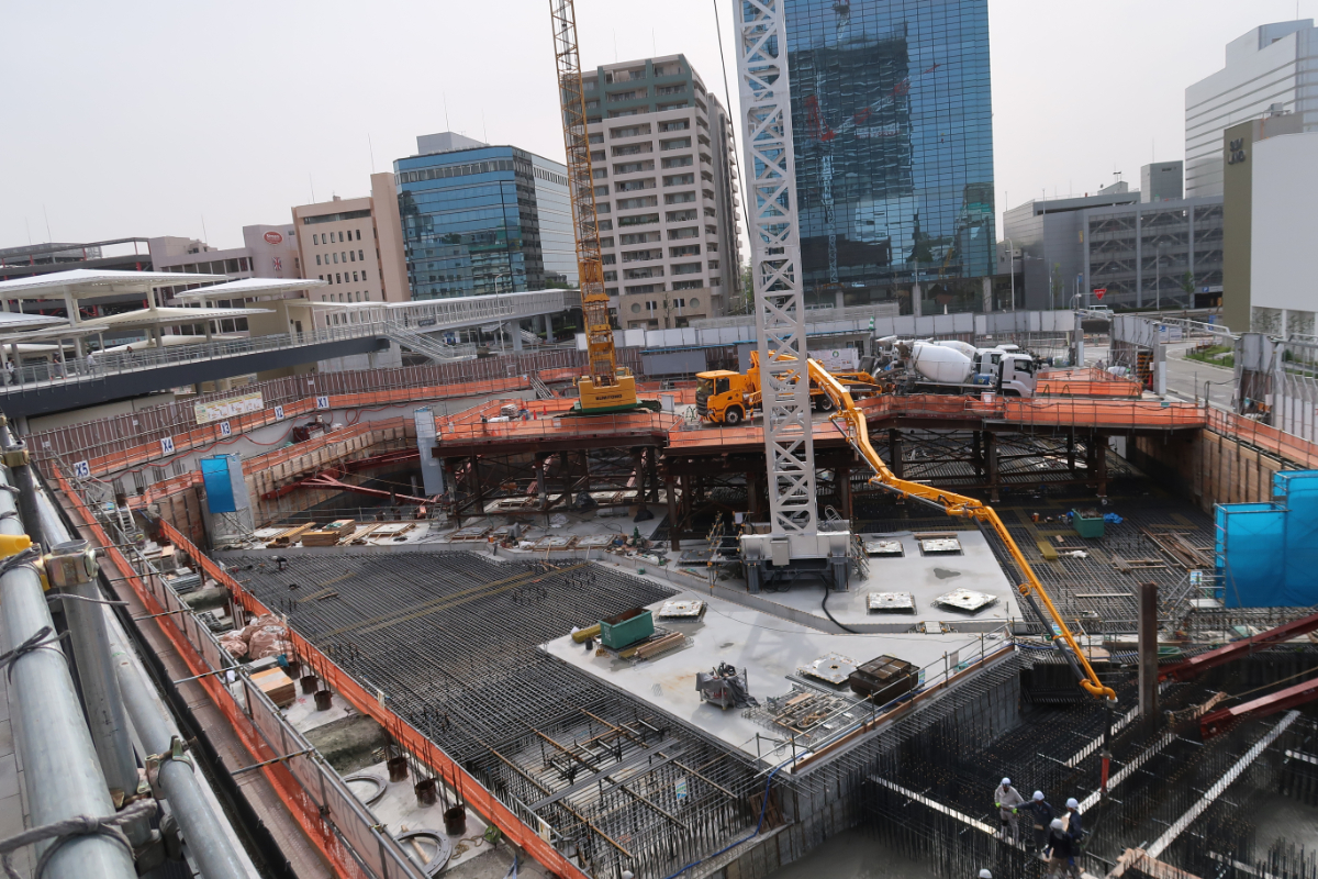 箕面船場阪大前駅の界隈では、2023年4月現在も未だに開発工事が進んでいます。左上の白い傘の地下３階に駅があります。丘陵地帯を走るため、箕面船場阪大前駅がある地下３階から、すぐに地上に出て高架を走り箕面萱野駅に到着します