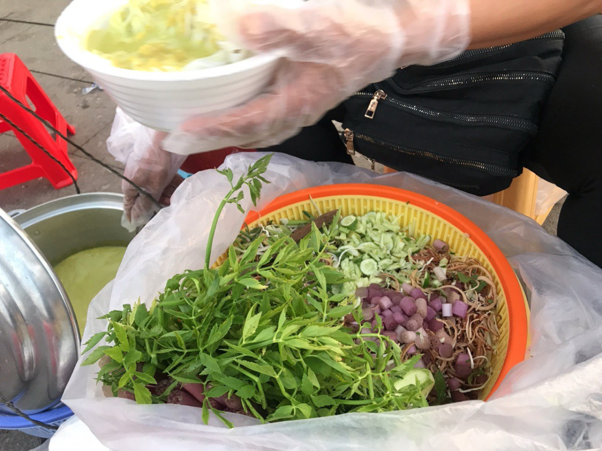 麺にスープをかけて、たくさんの野菜やハーブをトッピングしていただく
