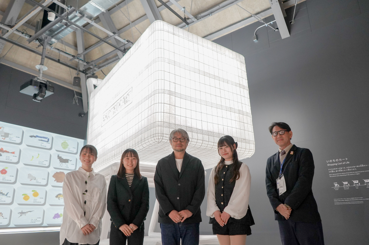 「大阪・関西万博 EARTH MARTプロジェクト」 2025 完成した高さ4メートルのオブジェの前で。小山薫堂副学長(中央)、森岡さん(右)、プロジェクトメンバーの学生たちと共に
