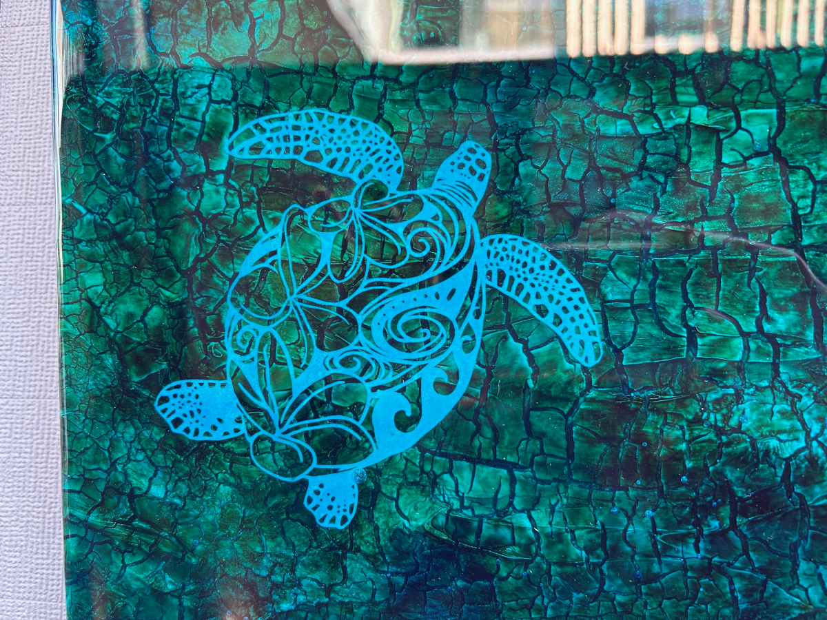 独自の世界を展開するフィンアーティストのYURIE氏による下絵を元に制作した山口さんの切り絵を、BRIWOOD・HIKARU氏がレジンアートに昇華。三者がバトンをつなぐように制作。クラックが神秘的