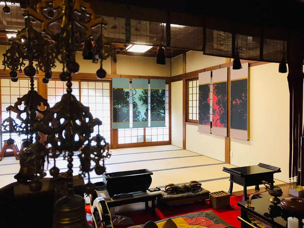 クサバノカゲ インスタレーション 金剛院本堂内掛け軸展示 2023 兵庫県加西市 火祭アートフェスティバル2023 - 兵庫県加西市に伝わる民話『女切ろまん』から生まれた〈クサバノカゲ〉シリーズ。てると市兵衛という二人の男女、てるの許嫁である源四郎による悲劇を元に、本作では、彼らの墓上にある木を黄昏時に撮影。現地の伝統産業である播州織に写真を転写し、会場となった金剛院本堂を囲うように展示。住職が掛け軸に仕上げられた本作をかけ、御詠歌を歌い、お経を上げるパフォーマンスも行われた