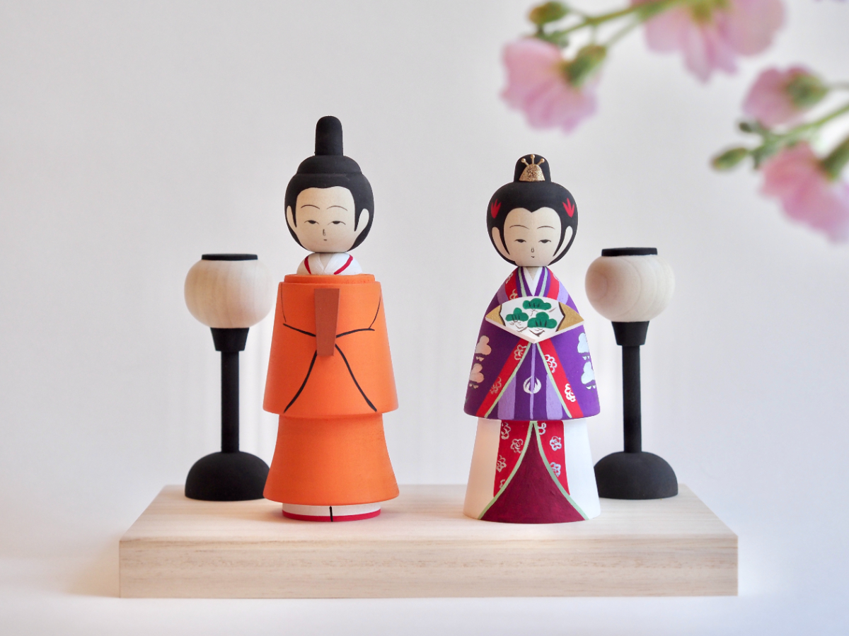 お雛様こけし 制作:髙橋博人(弥治郎系) – お雛様の十二単衣は、上皇后陛下ご成婚時の色合わせを忠実に再現し、こけし工人ならではの造形美、伝統模様をあしらった。製材時に白い木を選び抜き、薬剤による漂白を行わずに仕上げた一品